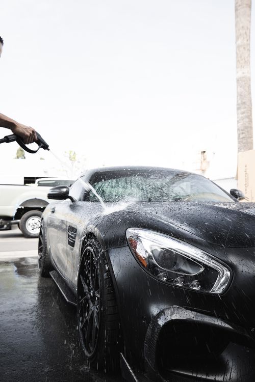Water rinsing a glossy black car